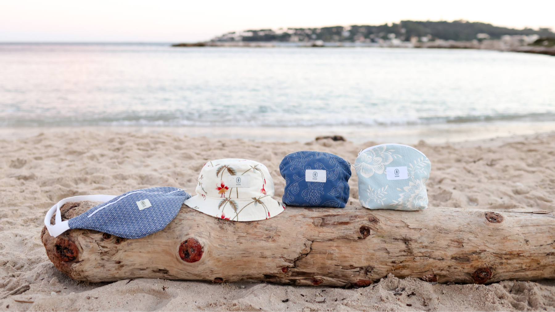 Accessoires en tissu upcyclé ÉTOFÉ: sac banane, bob et pochettes durables, sur fond de plage de la Côte d'Azur