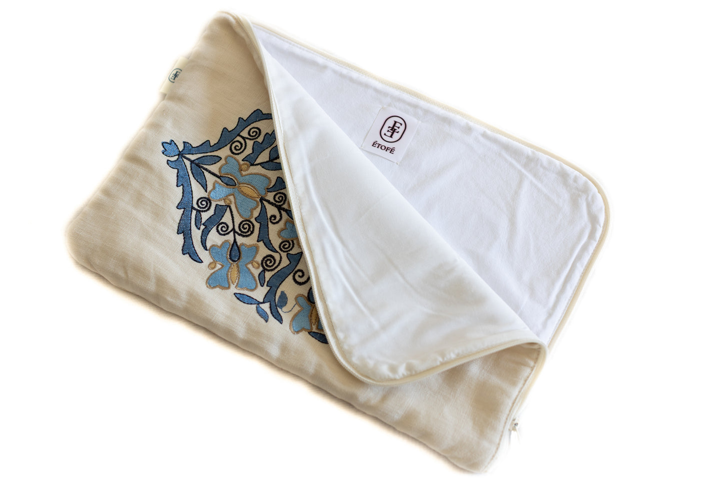 Housse artisanale avec broderie florale bleue, doublée en coton blanc et étiquette ÉTOFÉ, fabriquée à partir de tissu revalorisé.