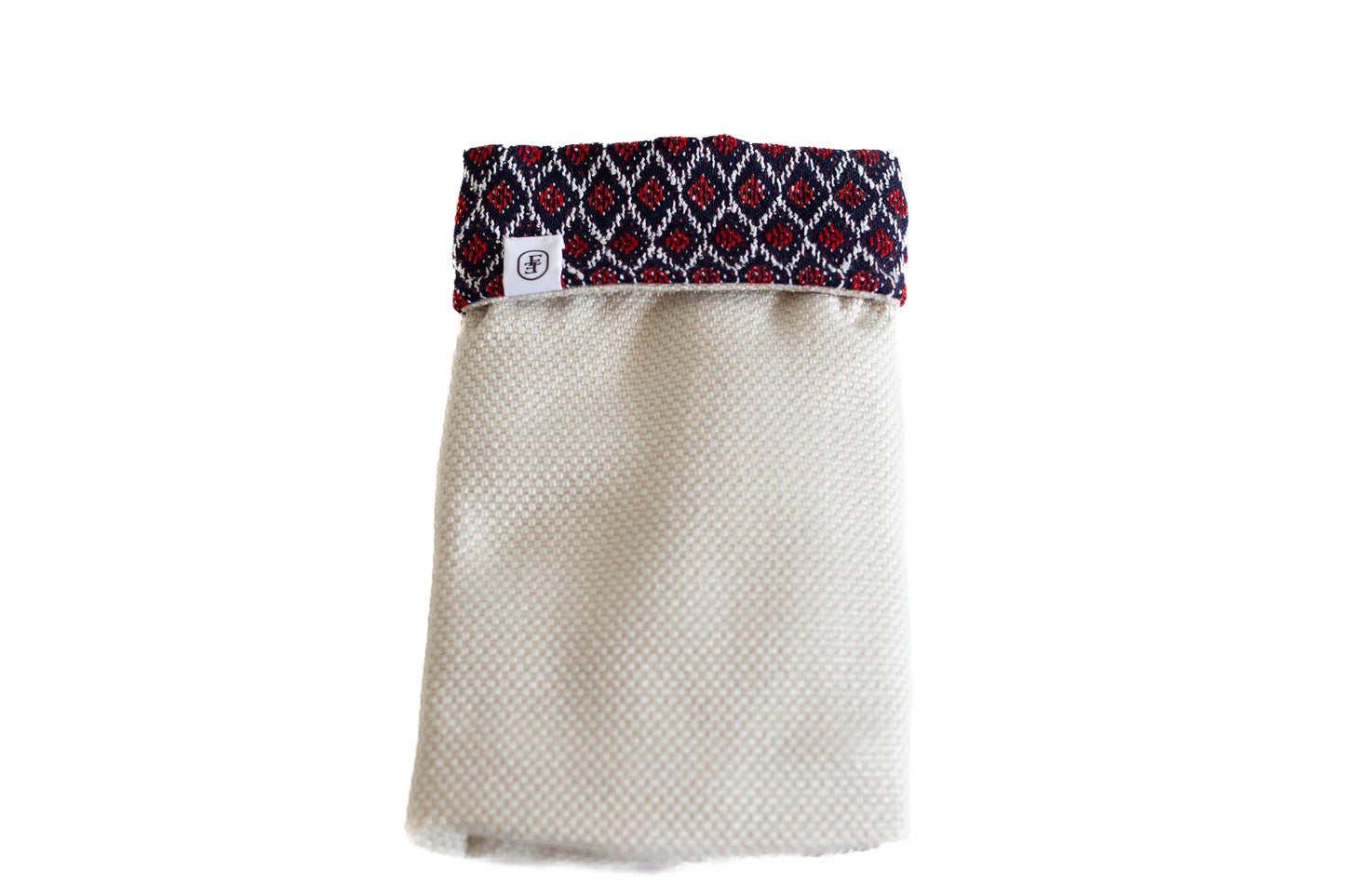 Pochette ÉTOFÉ beige avec revers à motifs ethniques rouges et noirs, confectionnée à la main à partir de textiles hôteliers revalorisés, dans une démarche durable et locale.
