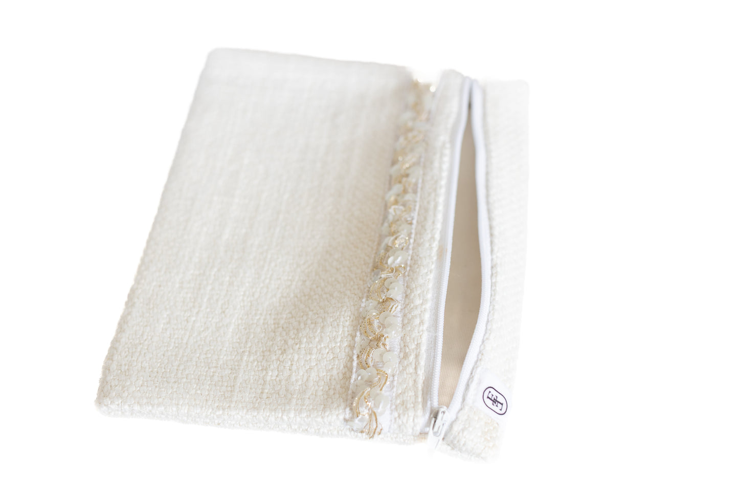 Pochette plate ÉTOFÉ en tissu blanc bouclette ouverte, avec fermeture éclair blanche et galon doré, vue de trois quarts.