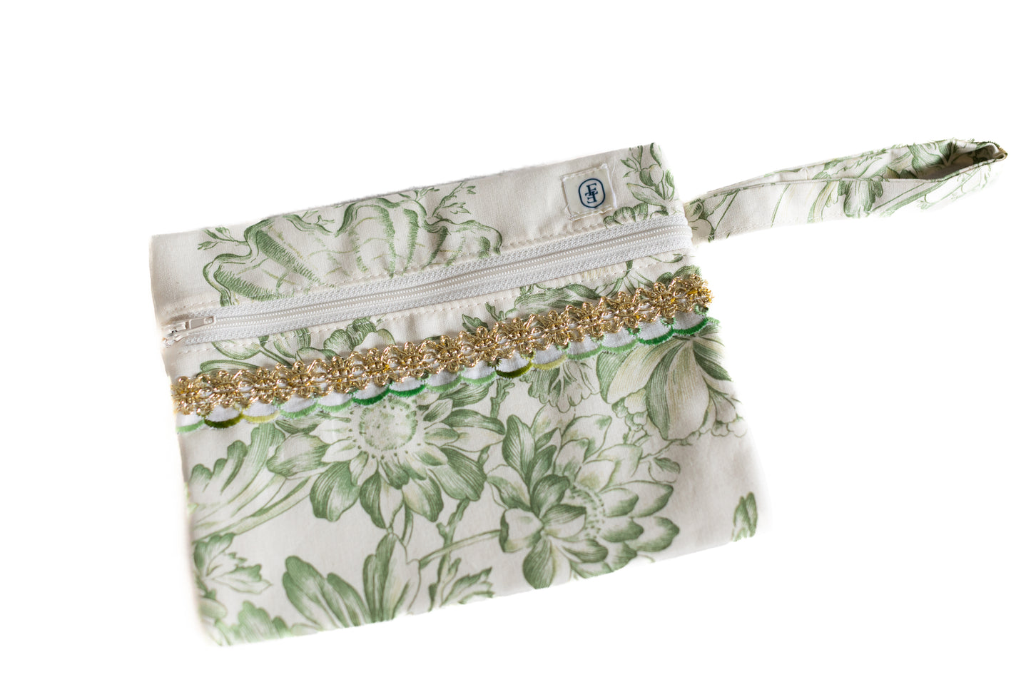 Pochette plate ÉTOFÉ en tissu upcyclé imprimé de fleurs vertes, ornée d’un galon doré à motifs floraux et d’une poignée assortie.