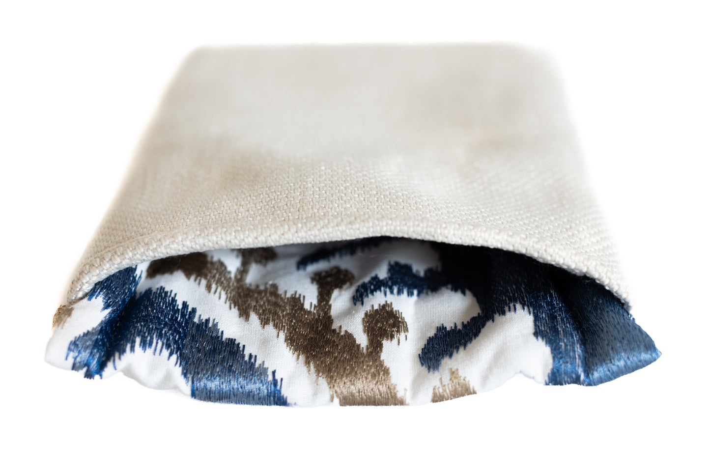 Pochette beige en tissu revalorisé, laissant apparaître un intérieur bleu et beige. Création artisanale aux valeurs durables, réalisée sur la Côte d’Azur.