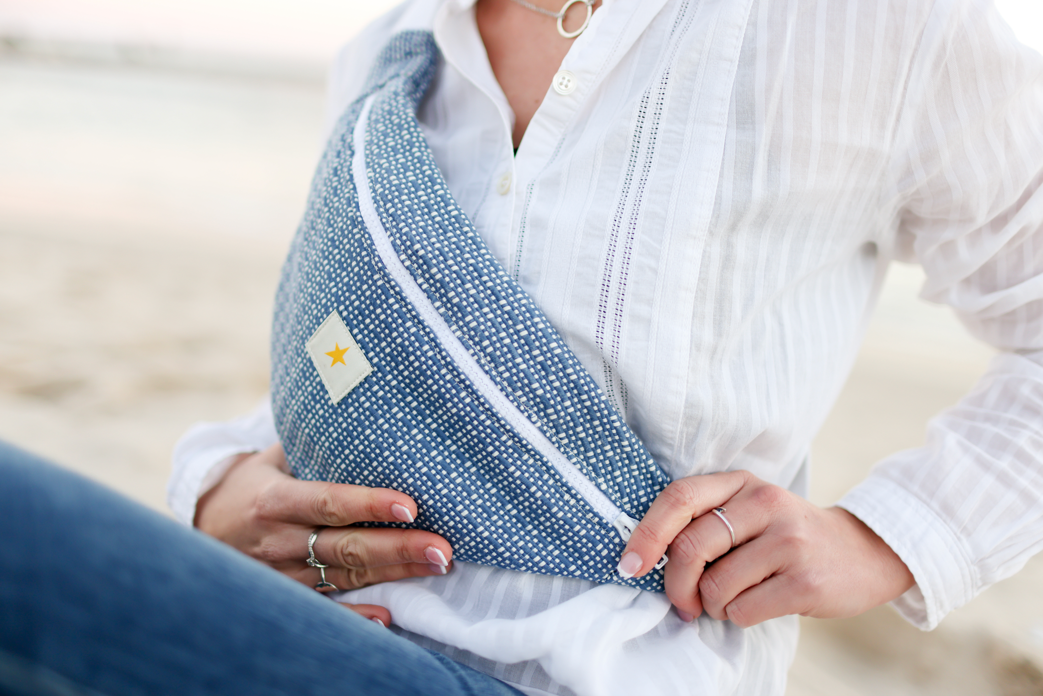 Sac banane bleu en tissu revalorisé porté à la plage, confection artisanale et éthique.