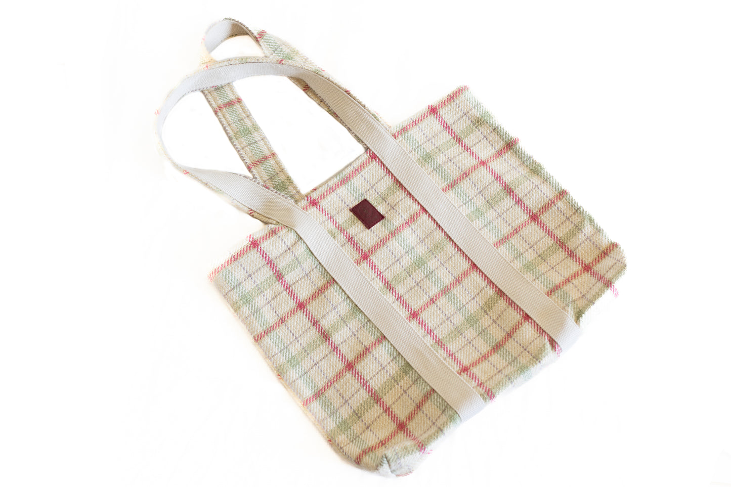 Sac cabas ÉTOFÉ en tissu recyclé à carreaux beiges et rouges, anses écrues, pris en angle sur fond blanc.