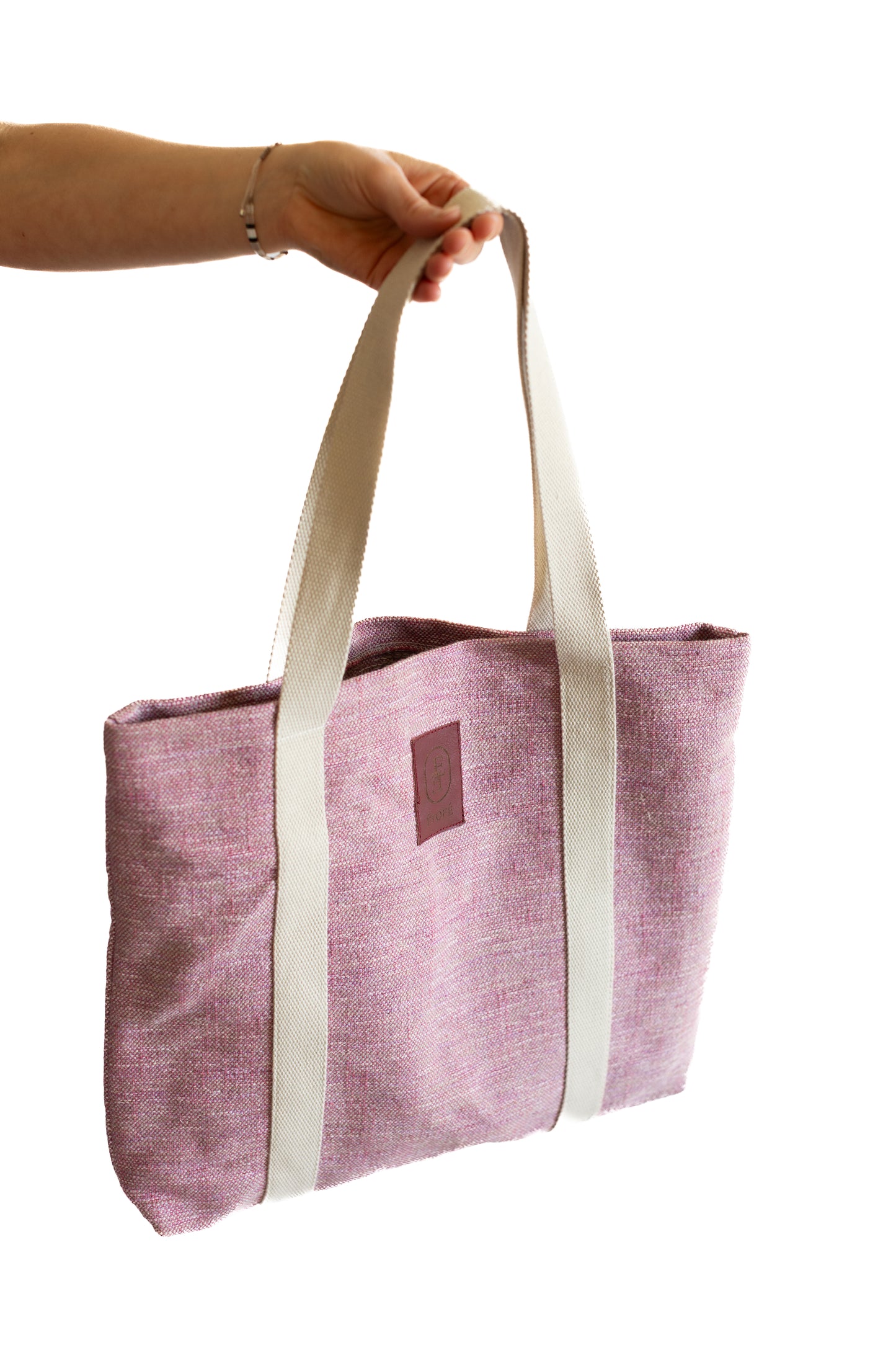 Sac tote bag ÉTOFÉ rose en tissu upcyclé, porté à la main avec poignées en coton écru, vue côté gauche, style minimaliste et artisanal.