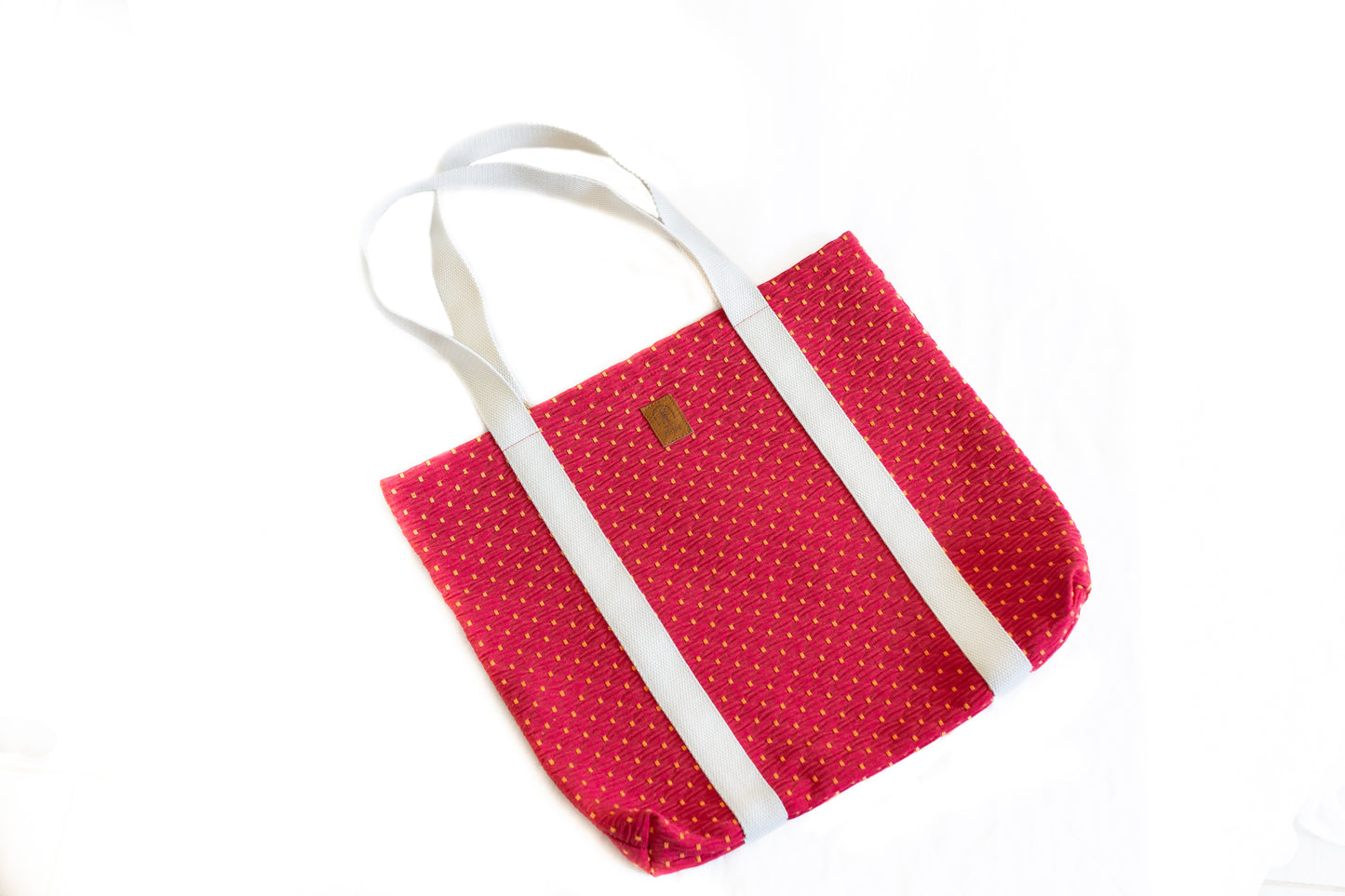 Sac tote bag ÉTOFÉ en tissu recyclé rouge avec motifs jaunes, poignées écrues, présenté de face sur fond blanc.