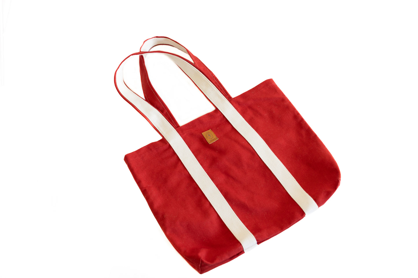 Sac cabas ÉTOFÉ en tissu recyclé rouge vif, anses écrues, vu de côté sur fond blanc.