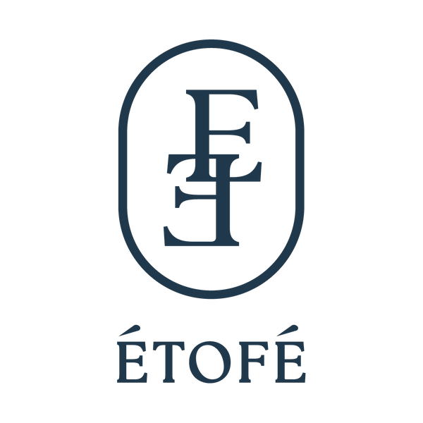 Logo de la marque ÉTOFÉ, constitué d’un monogramme stylisé bleu marine avec les lettres entremêlées “E” et “F” dans un ovale, accompagné du nom “ÉTOFÉ” en majuscules élégantes en dessous.
