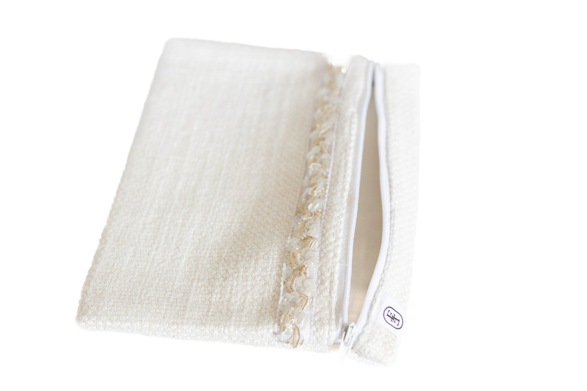 Pochette plate ÉTOFÉ en tissu blanc bouclette ouverte, avec fermeture éclair blanche et galon doré, vue de trois quarts.