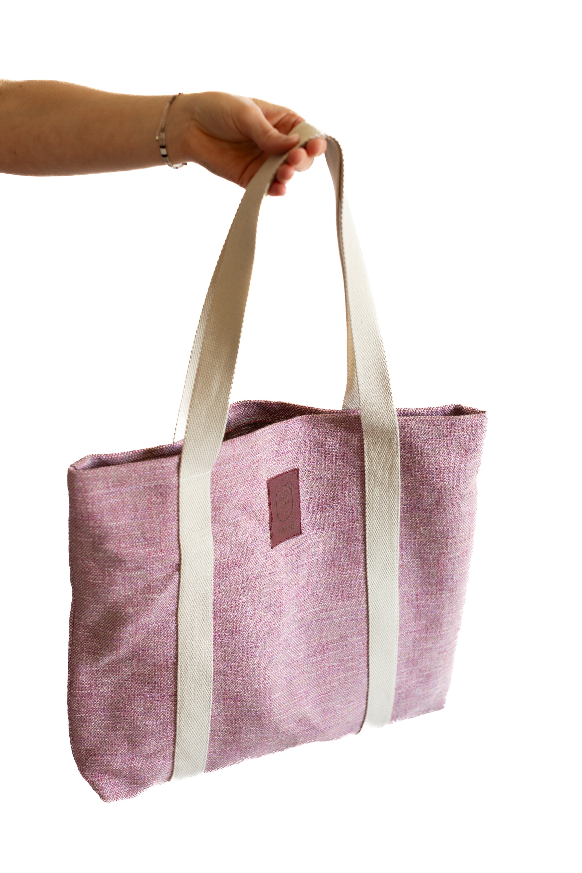 Sac tote bag ÉTOFÉ rose en tissu upcyclé, porté à la main avec poignées en coton écru, vue côté gauche, style minimaliste et artisanal.