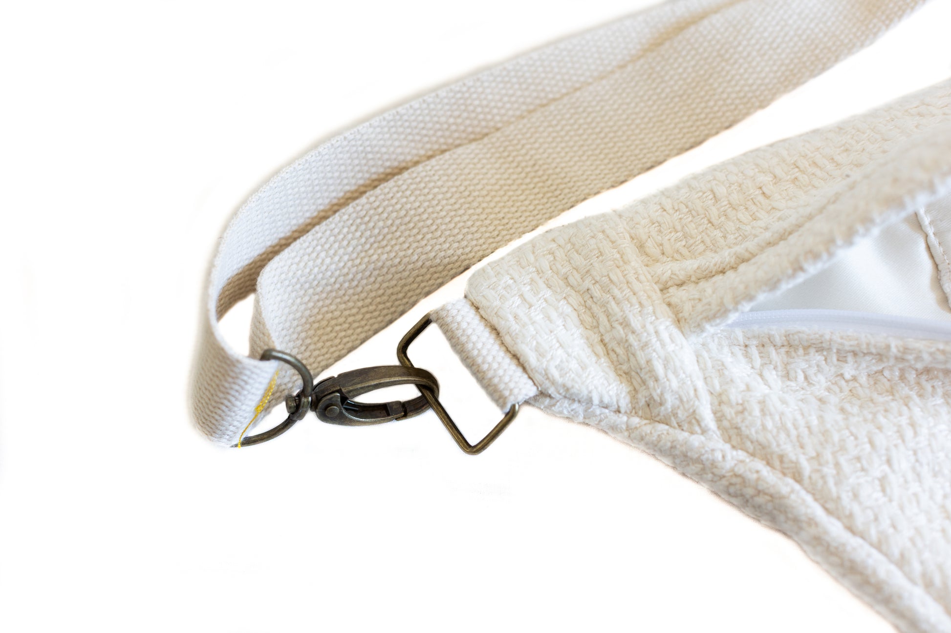 Gros plan sur l’attache en métal de la banane blanche en tissu bouclé Étofé, avec sangle épaisse et doublure claire.